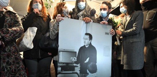 Familiares y colegas sostienen una foto de Samuel Paty durante la 'Marcha Blanca' en su honor al noroeste de París.