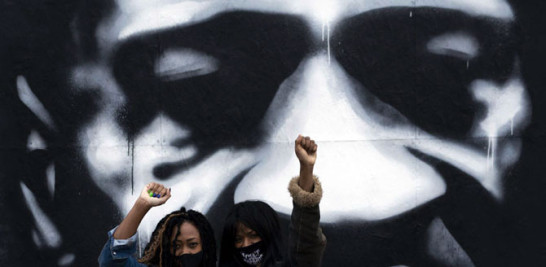 Dos mujeres negras levantan el puño ante un mural de George Floyd en Minneapolis, el pasado octubre. STEPHEN MATUREN GETTY IMAGES/ AFP