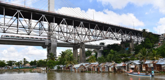 Cinco formas de transporte se viven a diario en el entorno del río Ozama. Metro y vehículos en el puente y más arriba teleférico. En el río bote con motor y barco, como una muestra de diferentes etapas de desarrollo y pobreza. /ADRIANO ROSARIO