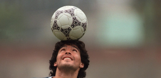 Diego Maradona, con un pendiente de diamantes, balancea una pelota de fútbol sobre su cabeza mientras camina fuera del campo de práctica después de la sesión de práctica de la selección nacional en la Ciudad de México. JORGE DURAN