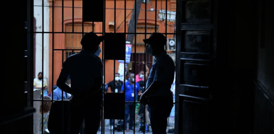 Oficiales de seguridad observan atentamente en una puerta de ingreso a la prisión Najayo-Hombres, en San Cristóbal.