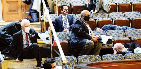 Congresistas se cubren en momentos en que los asaltantes interrupieron la sesión congresional. AP