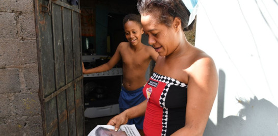 La madre de Alan observa el ejemplar del Listín donde salió la historia de su hijo. ADRIANO ROSARIO/LD