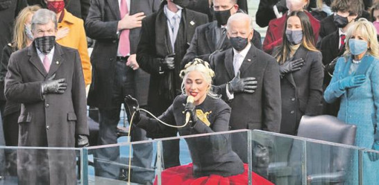 Jennifer López cuando cantaba ayer un popurrí de America the Beautiful y This Land Is Your Land. A la derecha, Lady Gaga interpretando el himno estadounidense. AP