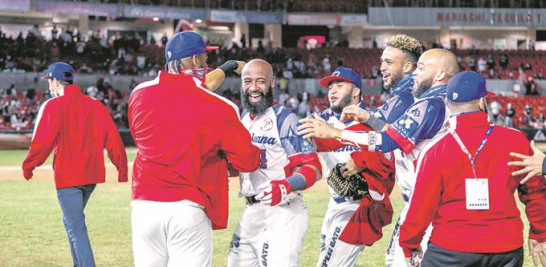 Carlos Paulino es congratulado por varios de sus compañeros segundos después de conectar el imparable ganador para que las Aguilas avanzaran a la final de la Serie del Caribe a efectuarse este sábado.