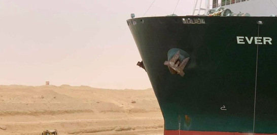 En esta imagen difundida por la Autoridad del Canal de Suez, un carguero llamado Ever Green se ve con la proa encallada en el muro del canal, el miércoles 24 de marzo de 2021, tras quedarse atravesado y bloquear el Canal de Suez, en Egipto, cortando un paso crucial para el tráfico global de mercancías. (Autoridad del Canal de Suez via AP)