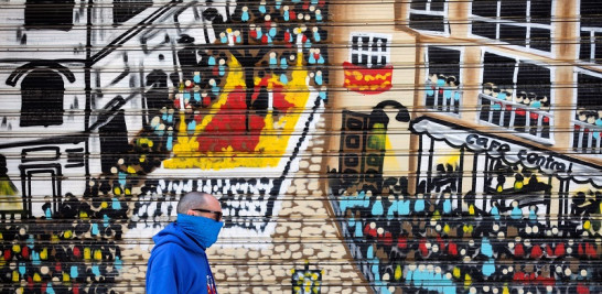 Una persona camina delante de un mural sobre la Semana Santa). EFE/Daniel Pérez