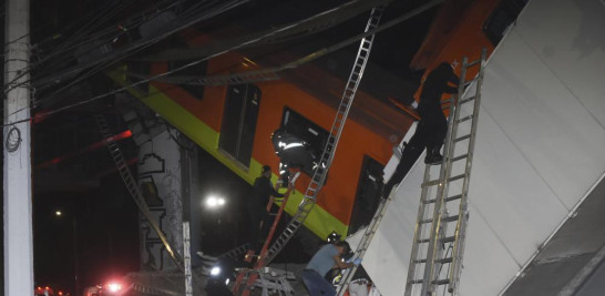 Bomberos y personal de rescate de Ciudad de México trabajan para recuperar a las víctimas de un vagón del metro que cayó luego de que una sección de la Línea 12 del metro colapsara en Ciudad de México, el lunes 3 de mayo de 2021. La sección que pasa sobre una carretera en el sur de la capital mexicana colapsó el lunes por la noche, dejando caer un tren subterráneo, atrapando autos y causando al menos 50 heridos, dijeron las autoridades. (AP Foto/Jose Ruiz)
