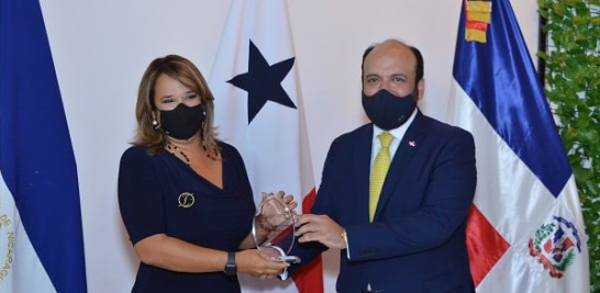 El viceministro de MICM Ramón Perez entrega una placa a Isabel Estévez..