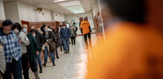 La gente hace cola para vacunarse en una escuela secundaria de Central Falls, Rhode Island, el 20 de febrero del 2021. La pequeña ciudad, con una enorme comunidad latinoamericana, tiene una de las incidencias del COVID-19 más altas de EEUU. (AP Photo/David Goldman)