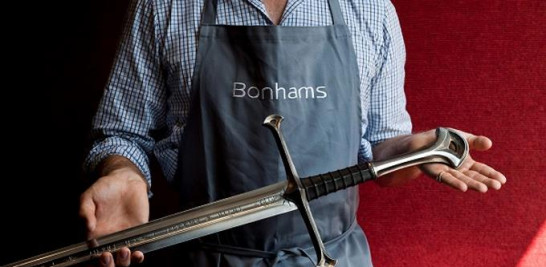 Un empleado de Bonhams muestra la espada del héroe de Aragón 'Anduril' de la trilogía cinematográfica de El Señor de los Anillos en la casa de subastas Bonhams en Londres, Gran Bretaña, 31 de julio de 2014.