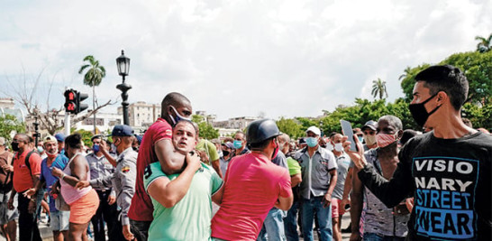 Un hombre es agarrado por el cuello durante una manifestación contra el gobierno cubano. / AFP