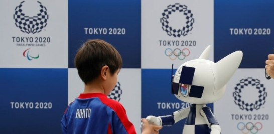 6.-Un niño le da la mano a Miraitowa, la mascota robot de los Juegos Olímpicos de Tokio 2020. EFE/ Kimimasa Mayama