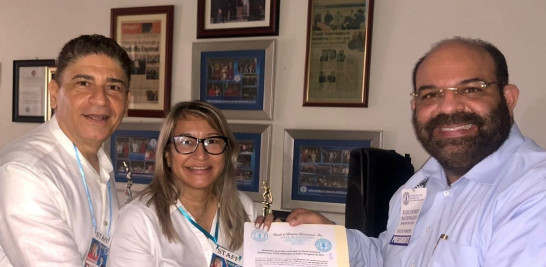 Hilda María Peguerro recibe así certificación como ganadora del abogado Félix Portes y Bismark Morales.