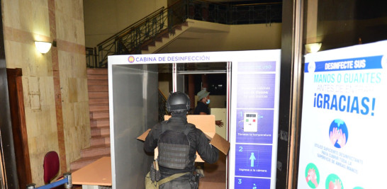Un agente carga documentos allanados en la Operación Falcón. Onelio Domínguez/ Listín Diario.
