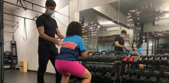 El fisioterapeuta Carlos Salinas durante una sesión de entrenamiento en su gimnasio a una de sus pacientes. /FUENTE EXTERNA