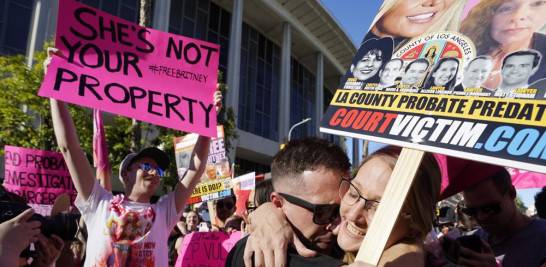 Los simpatizantes de Britney Spears Aaron Morris, segundo de derecha a izquierda, y Elizabeth Crocker se abrazan fuera de una audiencia sobre la tutela de la cantante pop en la corte Stanley Mosk el viernes 12 de noviembre de 2021 en Los Angeles. (Foto AP/Chris Pizzello).