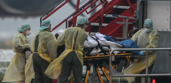 En Baviera, Alemania, médicos transfieren pasajeros infectados con Covid-19 a un avión para ser llevados a UCI. / AFP