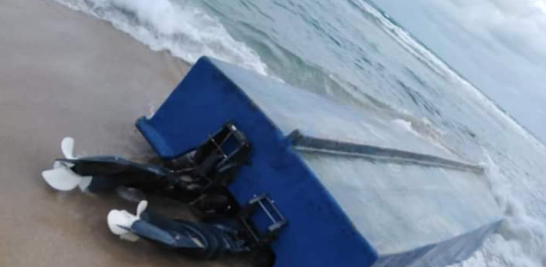 Una embarcación de constitución frágil virada sobre una línea de playa dominicana. listín diario