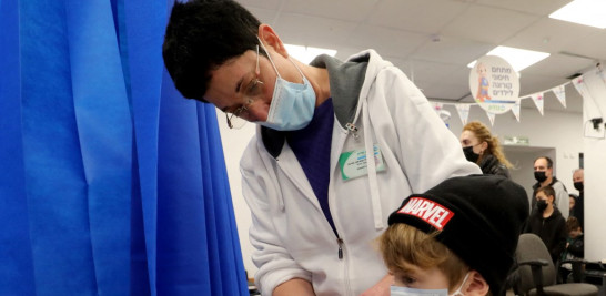 Un trabajador de la salud israelí administra una dosis de la vacuna Pfizer-BioNTech COVID-19 a un niño en los Servicios de Salud Clalit en la ciudad central israelí de Modiin el 2 de enero de 2022. GIL COHEN-MAGEN / AFP