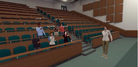 Fotografía cedida por Optima Classical Academy que muestra una de sus clases de realidad virtual 3D donde aparece una profesora mientras imparte su clase a unos alumnos en un anfiteatro.