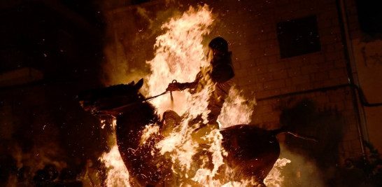 Un jinete cabalga a través de una hoguera en el pueblo de San Bartolomé de Pinares, en la provincia de Ávila, en el centro de España, durante la tradicional fiesta religiosa de "Las Luminarias" en honor a San Antonio Abad (San Antonio), patrón de los animales, en 16 de enero de 2022.
PIERRE-PHILIPPE MARCOU / AFP