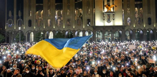 Los manifestantes sostienen sus teléfonos inteligentes con antorchas encendidas mientras se ondea una bandera ucraniana durante una manifestación en apoyo de Ucrania, en Tbilisi el 25 de febrero de 2022. Unas 30.000 personas se manifestaron en la capital de Georgia en una manifestación de solidaridad con el país exsoviético Ucrania.
Vano Shlamov / AFP