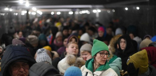 Refugiados esperando para abordar un tren para Polonia desde la estación de trenes de Leópolis/ AFP