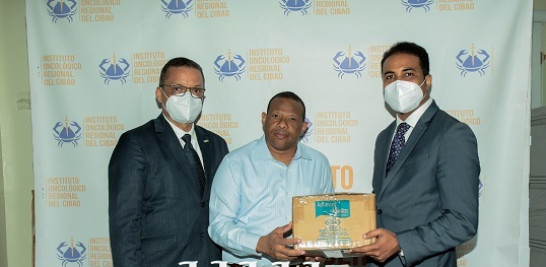Willy González y José Ozoria, de LAM, entrega donativo al Patronato Lucha Cáncer de Santiago, recibido por Héctor Lora.