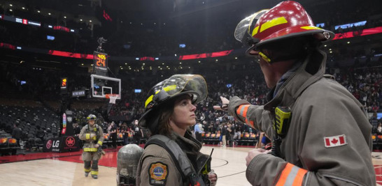El partido de baloncesto de la NBA entre los Toronto Raptors y los Indiana Pacers se suspende mientras los bomberos trabajan para evacuar el edificio, durante la primera mitad del sábado 26 de marzo de 2022 en Toronto. (Frank Gunn/The Canadian Press vía AP)
