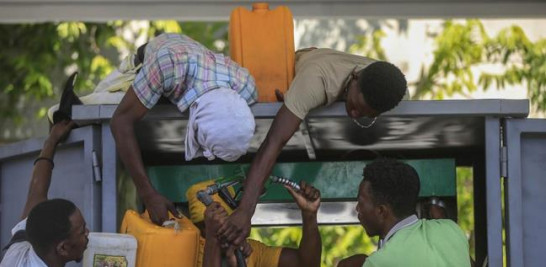 Varias personas se disputan un despachador en una bomba de gasolina en Haití. Foto de archivo : AP/Odelyn Joseph.