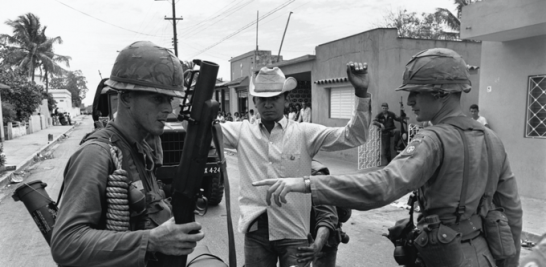 Soldados de Estados Unidos registran a un ciudadano en una calle de Santo Domingo. / GETTY IMAGEN