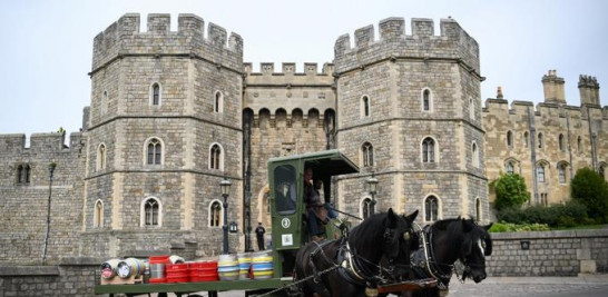Un coche de caballos pasa por delante del Castillo de Windsor, la residencia de la Reina Isabel II, mientras entregan a los bares diferentes cervezas elaboradas por la cervecería Windsor & Eton en Windsor, Inglaterra, el 28 de abril de 2022. Foto: Daniel Leal/AFP.