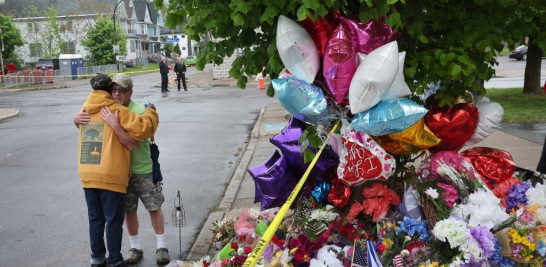 La gente visita un monumento improvisado instalado fuera del supermercado Tops el 18 de mayo de 2022 en Buffalo, Nueva York. Un hombre armado abrió fuego en la tienda el sábado, matando a 10 personas e hiriendo a otras tres. La policía dice que está siendo investigado como un crimen de odio por motivos raciales. Scott Olson/Getty Images/AFP