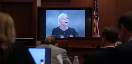 La actriz Ellen Barkin aparece en un monitor mientras se reproduce un testimonio grabado de 2019 durante el juicio por difamación de 50 millones de dólares de Depp contra Heard en el Tribunal de Circuito del Condado de Fairfax en Fairfax, Virginia, el 19 de mayo de 2022. Foto: Shawn Thew/AFP.