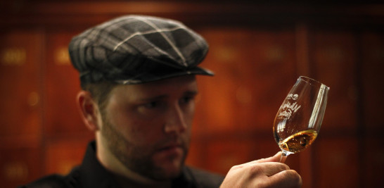 Un hombre degusta un trago de escocés de malta. Nic Bothma