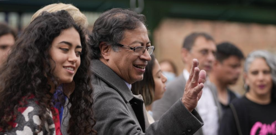 Gustavo Petro, candidato presidencial de la coalición Pacto Histórico, saluda al salir de un colegio electoral acompañado de su hija Andrea después de votar en una segunda vuelta presidencial en Bogotá, Colombia, ayer. AP
