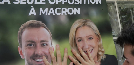 Un partidario de la líder de extrema derecha francesa Marine Le Pen, coloca un cartel de campaña en Aulnoy-Lez-Valenciennes, en el norte de Francia, en junio de este año. AP