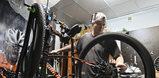 El mecánico de bicicletas Vitaliy, de 34 años, repara una bicicleta en una tienda de bicicletas en Kramatorsk, en medio de la invasión rusa de Ucrania el 2 de julio de 2022. En las últimas semanas, las tiendas han reabierto lentamente y muchas personas están regresando a Kramatorsk. Genya SAVILOV / AFP