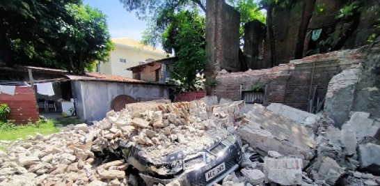 Un automóvil enterrado bajo los escombros de una casa en la ciudad de Vigan, Filipinas. Foto de AFP Forum.