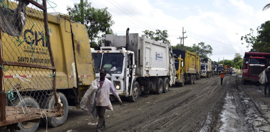 Una línea extensa de vehículos con basura a lo largo de la fangosa vía hacia el vertedero.  / J.A. Mandonado