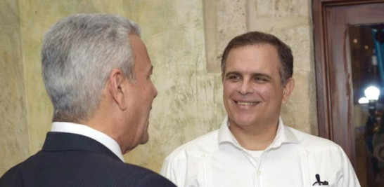 Jochy Vicente, ministro de Hacienda, sonrie junto a Macarrulla.