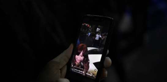 Una persona mira un video en un teléfono móvil que muestra a un hombre apuntando a la vicepresidenta argentina Cristina Fernández de Kirchner frente a su residencia en Buenos Aires el 1 de septiembre de 2022. AFP