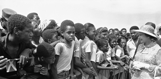 Escolares jamaicanos saludan a la reina Isabel II en el Monumento de los Héroes Nacionales en Kingston, Jamaica, el 14 de febrero de 1983, en el segundo día de la visita de la reina a la excolonia británica. (AP Foto/Kathy Willens, Archivo)