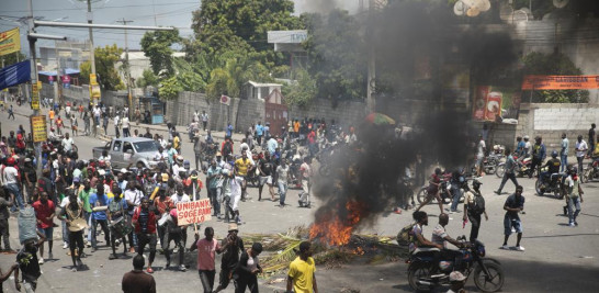 Un protestante se arrodilla mientras canta "Justicia para la gente" durante una protesta contra el alza de los precios de la gasolina y la renuncia del primer ministro haitiano Ariel Henry, el jueves 15 de septiembre. (AP Photo/Odelyn Joseph)