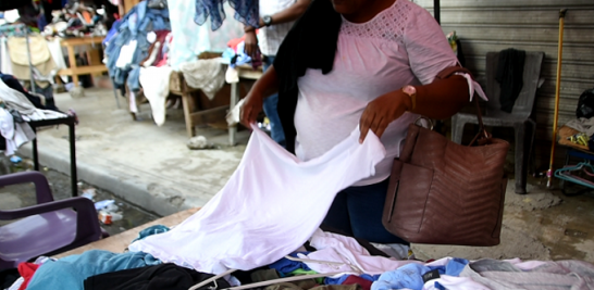 Una señora revisa una camiseta en una de las tantas carpas del mercado de San Cristóbal. RUBI MORILLO / LD