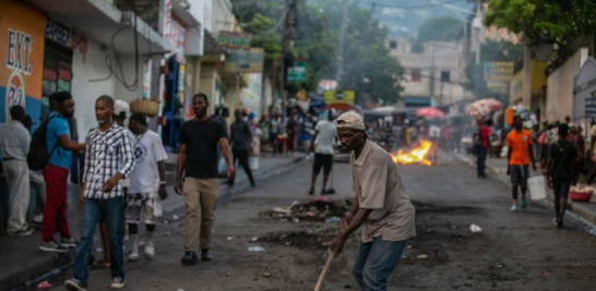 Haitianos se movilizan por las calles de un barrio afectado por protestas.