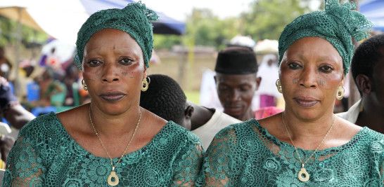 Las gemelas Taiwo Adebowale, izquierda, y Kehinde Adebowale, de 47 años, asisten al festival anual de gemelos en Igbo-Ora, suroeste de Nigeria, el sábado 8 de octubre de 2022. (Foto AP/Sunday Alamba)