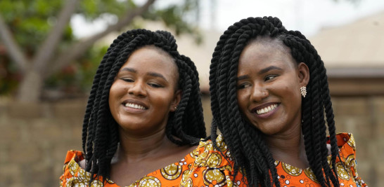 Gemelas Kehinde Adamolekun, izquierda, y Taiwo Adamolekun, de 28 años, asisten al festival anual de gemelos en Igbo-Ora, suroeste de Nigeria, el sábado 8 de octubre de 2022. (Foto AP/Sunday Alamba)