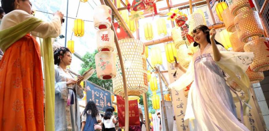 Una turista vestida con el Hanfu, un tipo de prenda tradicional china, posa para fotos con los faroles del Festival del Medio Otoño como telón de fondo en Shanghai, este de China, el 28 de agosto de 2022. (Xinhua/Chen Fei)